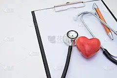 听诊器、红石人工心脏、白色背景的记录表放在桌上