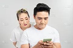 一对夫妇的照片，她看着她的男人屏幕和他欺骗他的爱人微笑在白色的背景孤立