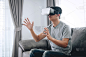 年轻的亚洲男子享受戴着玩虚拟现实头盔眼镜在家享受假期，3D小玩意技术，VR AR眼镜