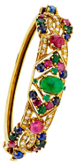 Multi-Stone, Diamond, Gold Bracelet----The hinged bangle is highlighted by an oval-shaped emerald cabochon weighing 2.00 carats, sapphire cabochons weighing a total of 2.50 carats, enhanced by ruby cabochons weighing a total of approximately 2.75 carats, 