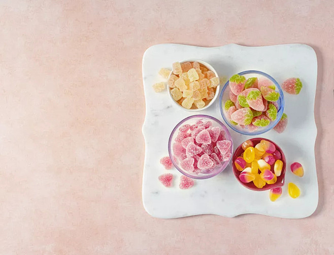 各种各样的橡皮糖在粉红色的背景碗图片