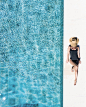 woman in black bikini bottom and white sun hat standing on blue water