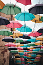 assorted umbrella hanging on wire during daytime