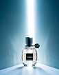 This may contain: a bottle of perfume sitting on top of a white table next to a blue wall