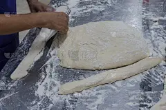 手切小面团，准备煎小的中国油条或中国甜甜圈作为早餐。