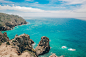 brown rock formation on blue sea under blue sky during daytime