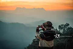 旅行者在日出时用智能手机拍摄风景照片。年轻女子周末快乐旅行。图片素材