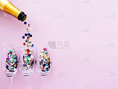 Gold champagne bottle and glasses with confetti on
