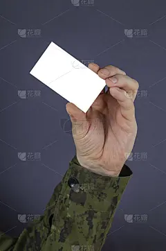 一个军官的手拿着一张空白的名片