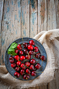 fresh cherries on wooden table by Eduardo Lopez on 500px