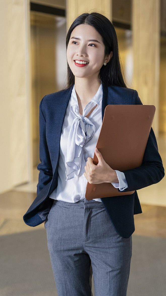 一手插兜一手抱文件的女人