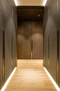 Case study - One Hyde Park, Knightsbridge. Design - Grangewood Finchatton. Joinery - INTERIOR-iD. Dressing Room with antique brass metal detailing, bespoke recessed handles fully integrated into framed wardrobe doors with woven leather and dark stained Ze