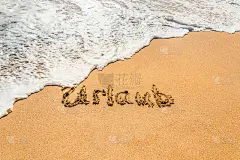 德文手写体Urlaub(英文翻译假期)上的金色沙滩上的沙浪迎面而来