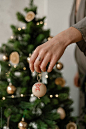 Crop Woman Decorating Christmas Tree by Alina Hvostikova