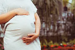 孕妇在家照顾孩子时感到快乐。年轻的孕妇抱着怀孕的肚子里的婴儿。孕产妇产前护理与妇女怀孕的概念。