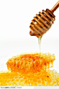 蜂蜜高清图片-木质搅拌棒上的蜂蜜滴在蜂巢上