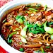 【酸辣牛肉粉】1.红薯粉丝热水泡开．油菜焯水，蒜苗切丝． 2.油热葱姜蒜爆香，入豆瓣酱炒出红油，放清水，加料酒，糖，盐，陈醋调味． 3.水开后入肥牛片和粉丝． 4.油菜铺底，肥牛片变色后盛出，撒蒜苗丝． 5．锅加油，烧热后炸干辣椒和花椒，辣椒油浇在蒜苗丝上即可。