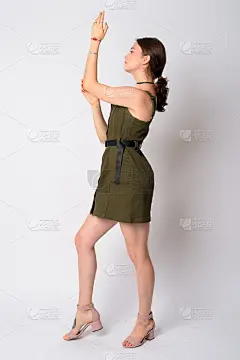 年轻美丽的女人举起手臂摆姿势的全身照侧面视图