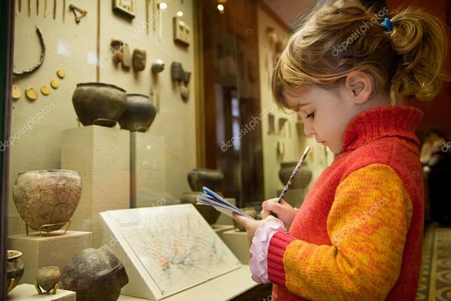 小女孩将写入到写作-在游览在历史博物馆附...
