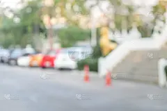 在官方场所模糊了室外停车场和炎热的太阳。汽车排成一排。模糊和抽象背景