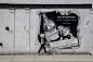 A person walking by an advertisement poster in front of a building in Central, Chicago, Illinois, USA