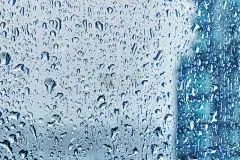 雨滴在窗户上在暴风雨的背景模糊，水滴背景