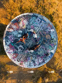 身穿黑色恤和蓝色牛仔裤的男子骑着自行车在圆形混凝土地板上