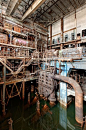 Image: Scott Haefner Stagnant green water has pooled at the bottom of this section of the power plant, no doubt hastening the decay of the machinery. In this photograph, you can see that rust has covered almost all of the metal parts.