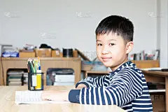 亚洲男孩在小学读书，在家自己阅读和做作业。