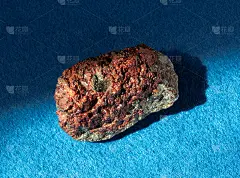 石榴石铝榴石晶体内岩石。在蓝色背景下分离出来的矿物。发现于俄罗斯乌拉尔的米亚斯市附近。地质矿物学网站