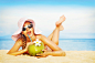 趴在沙滩上喝椰汁的美女高清图片