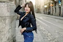 迷人的时尚现代女人戴着太阳镜站在城市街道上。夏天的肖像快乐的女孩在散步。