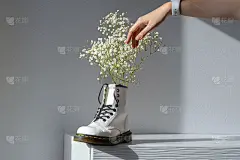 白色Gypsophila paniculata在白色女性靴子在白色的家内部。真实的照片。妇女节，母亲