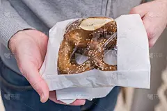 圣诞节在糕点店买椒盐卷饼的男人