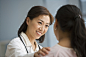 Asian doctor reassuring Hispanic female patient by Gable Denims on 500px