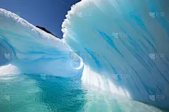惊人的波浪形状的冰山与完美的蓝色隧道