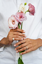 Woman showing her nail art on fingernails with flower