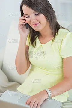 快乐的女人用她的笔记本打电话
