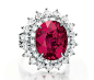 LOT 140 - A ruby and diamond ring, by Cartier. Set with an oval-cut ruby, weighing approximately 11.02ct, within a two row circular and marquise-cut diamond surround, mounted in platinum, in a Cartier red leather box. Signed Cartier, no. 87416. Sold for U