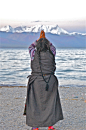Tibet : Lago Nam-tso (4730 m.): all'alba un'anziana prega rivolta verso i 7000 della catena del Nyenchen Tanglha.