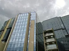 新建会展大厦、企业商务中心。玻璃表面。出租商业地产。城市景观。办公园区。阴暗的天空。经济和金融概念。