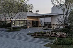 招商中旅中环臻邸 两侧弧形灰色景墙沿着场地舒展开来，仿若书卷徐徐展开，行走其间，移步异景。 环岛式的落客空间，塑造优雅的仪式感与领域感 发光 ...