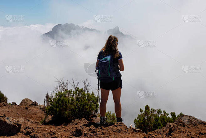 葡萄牙马德拉，站在多云的山顶上的女游客