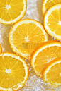 橙子片的近景为柠檬水的背景。夏日清凉甜饮的质感，玻璃墙上有宏观气泡。平面设计