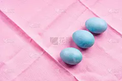 粉红色的桌布上放着蓝色的彩蛋
