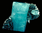 Beryl (variety: Aquamarine)    Although these two minerals grew side by side, they have different shapes. The atoms in beryl connect in a six-fold pattern and form six-sided crystals. The atoms in muscovite form layers that make sheet-like crystals.