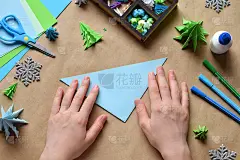 制作3D折纸圣诞树装饰或贺卡。圣诞快乐，恭贺新禧。孩子的DIY的概念。在假期亲手制作手工艺品。