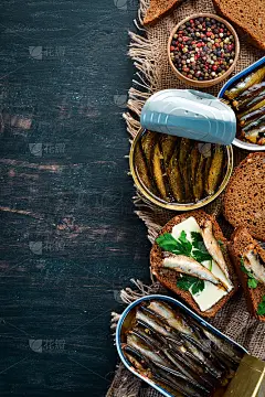 三明治的小人物。小人物在油中。在黑色的背景上。前视图。免费空间。