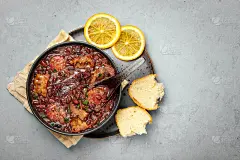 黑碗炖肉，灰色混凝土桌面。巴西和葡萄牙菜肴传统豆类肉炖