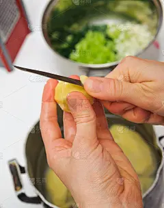 正在削土豆皮的女人。厨房工作。准备食物